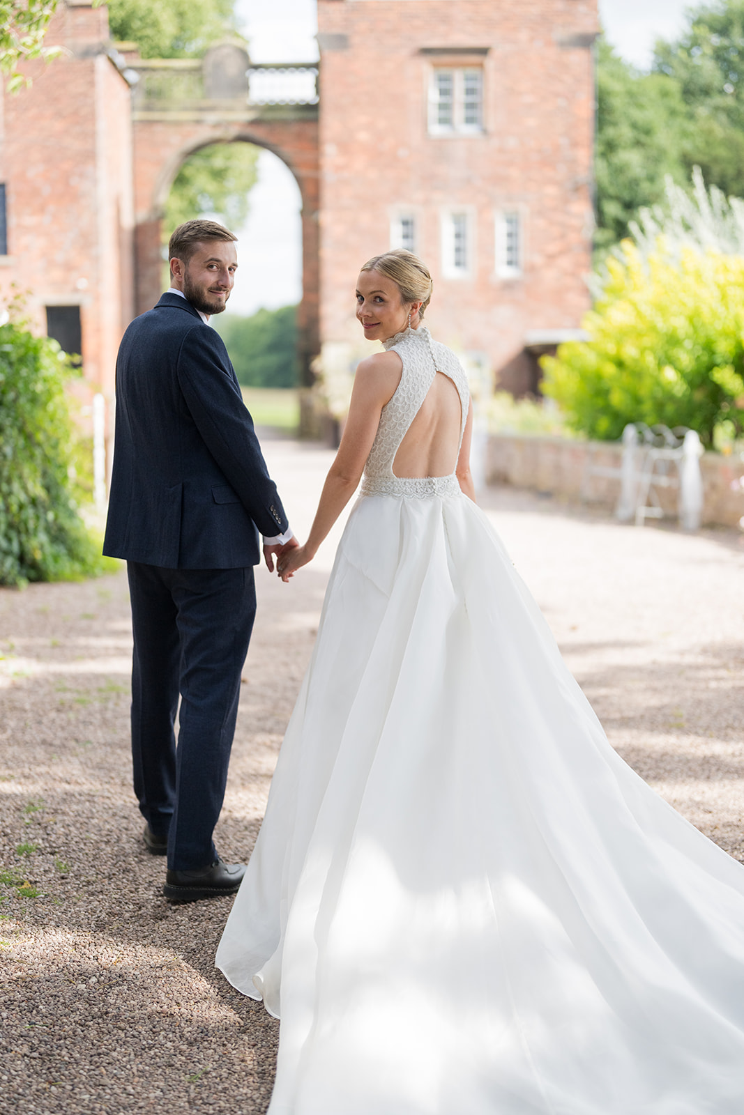 Bride looking back while holding hands with the groom