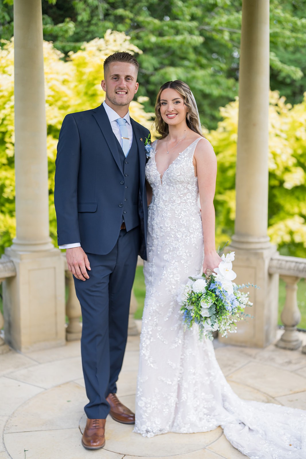 Bride and groom smiling together on a garden path