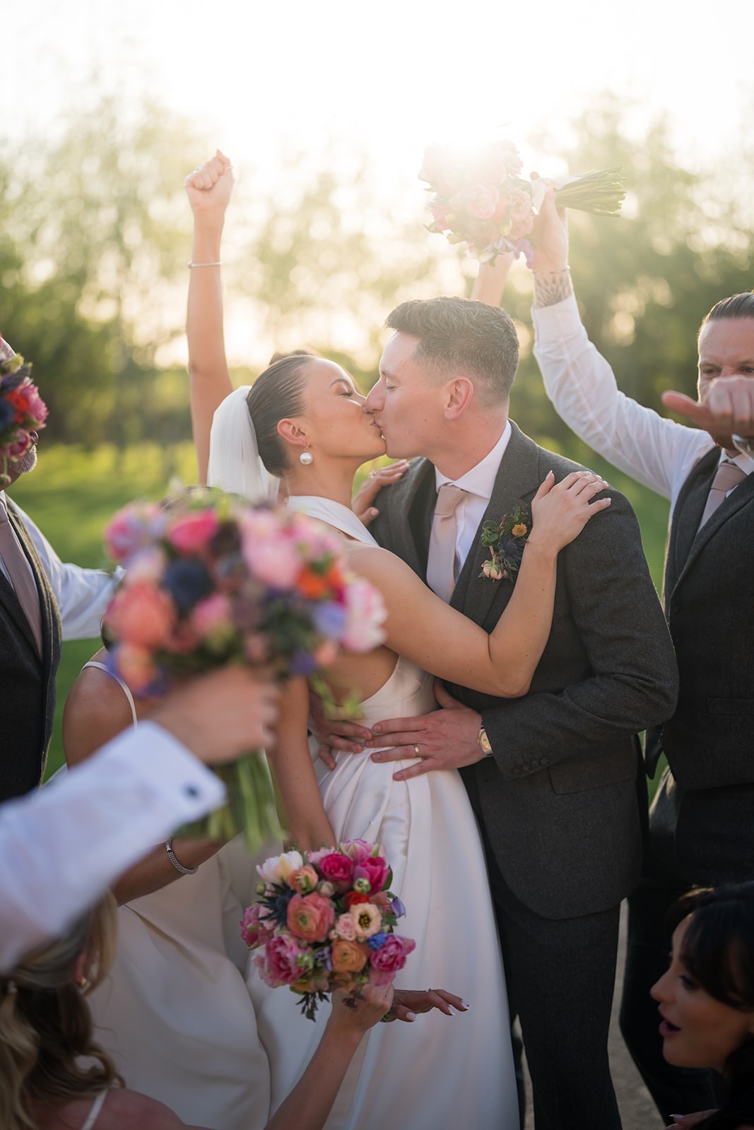 Newlyweds kissing in warm evening sunlight