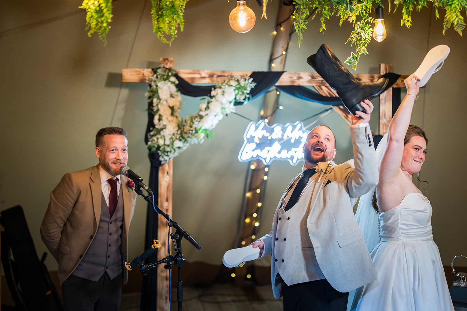 Wedding guests singing and raising their arms beside the band