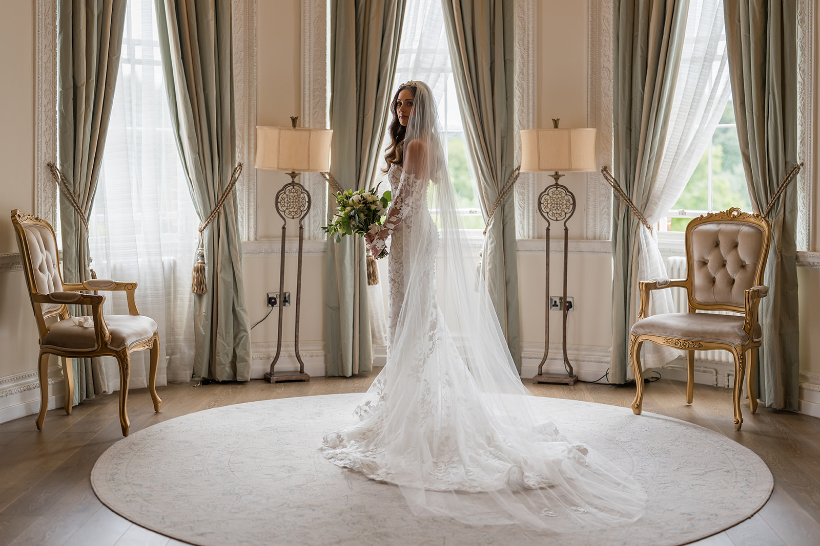 Bride and groom beneath a floral arch in an elegant ceremony room