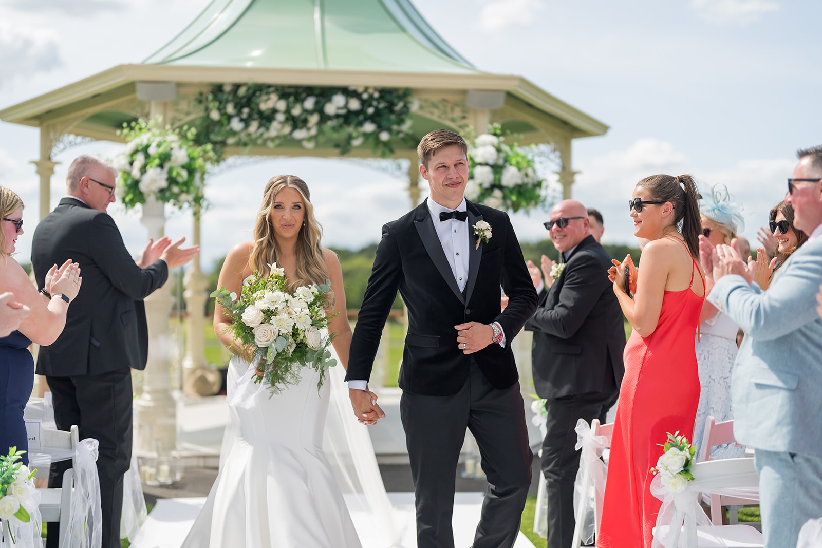 Newlyweds walking together after an outdoor wedding ceremony