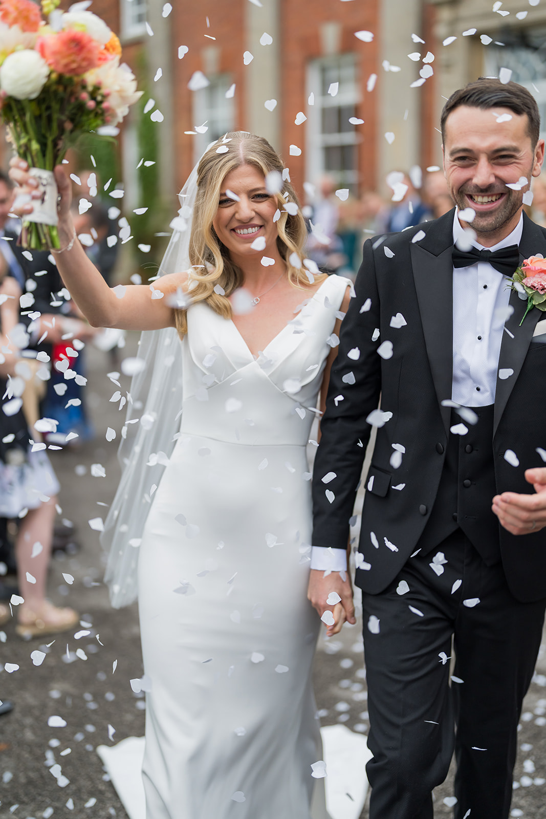 Newlyweds walking through a shower of confetti
