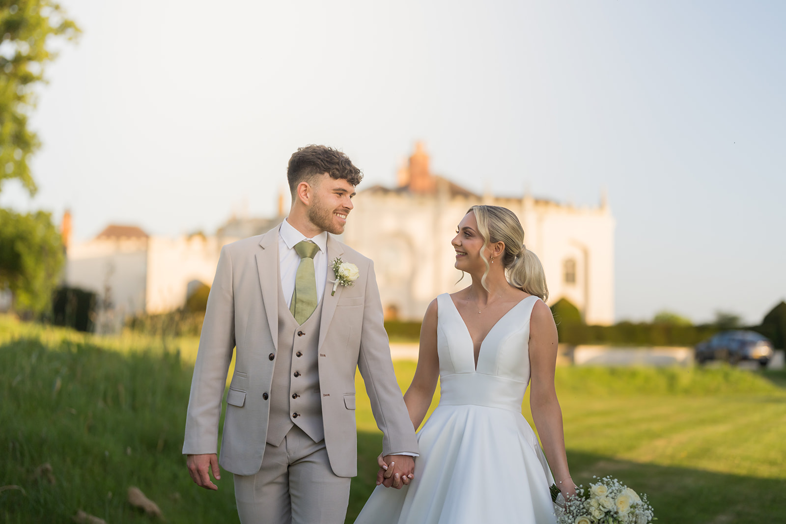 Newlyweds walking through a garden in golden evening light