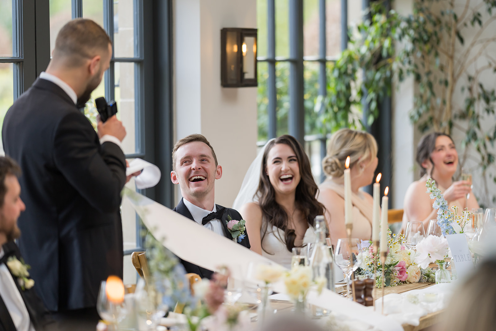 Bride and groom laughing during a wedding speech