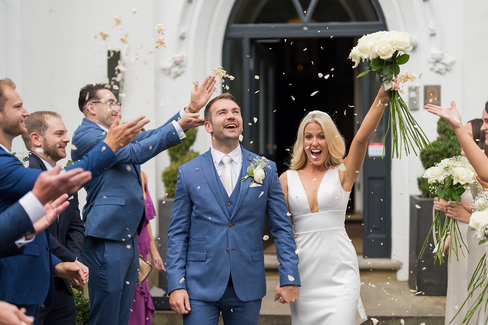 Newlyweds celebrating outside with their arms raised