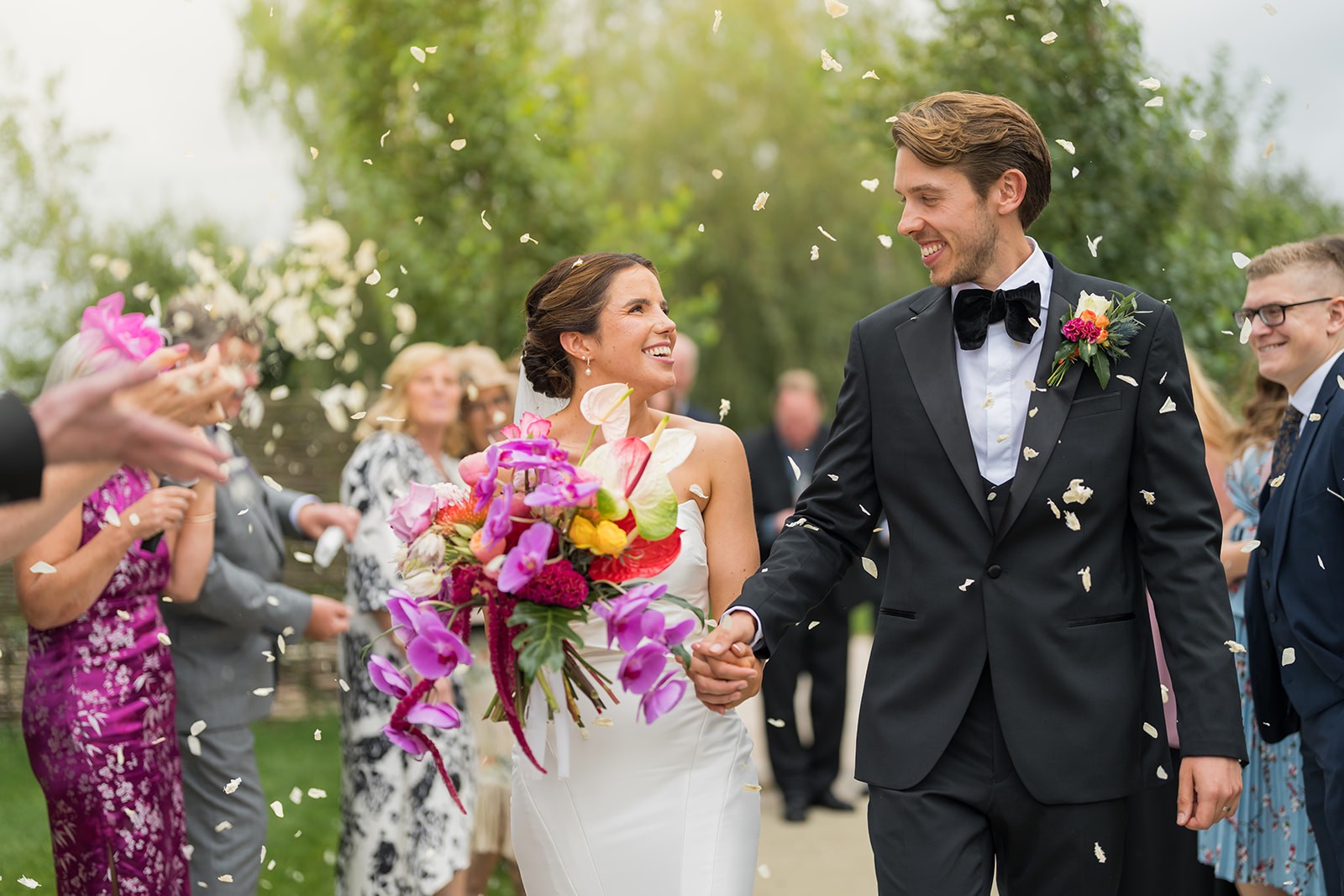 Newlyweds cheering beneath a shower of confetti