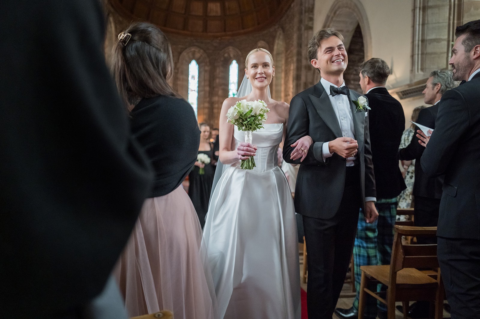 Newlyweds smiling at one another during a church ceremony