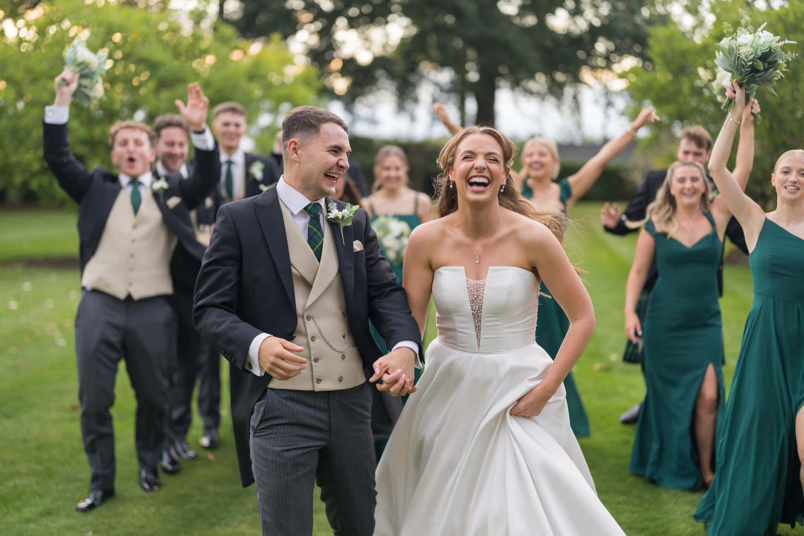 Bride and groom laughing as guests cheer them on