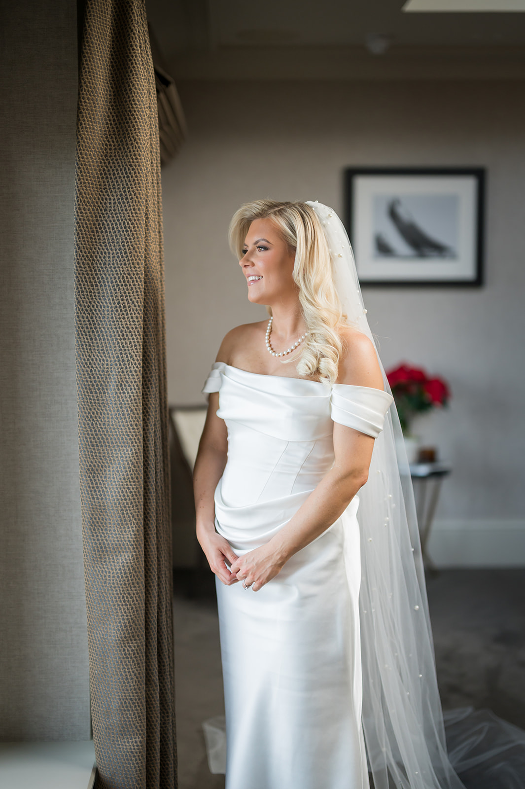 Bride standing in soft window light before the ceremony
