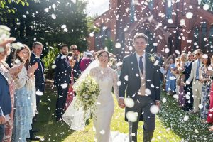 Wedding videography in the North West showing a videographer recording a couple during their wedding ceremony.