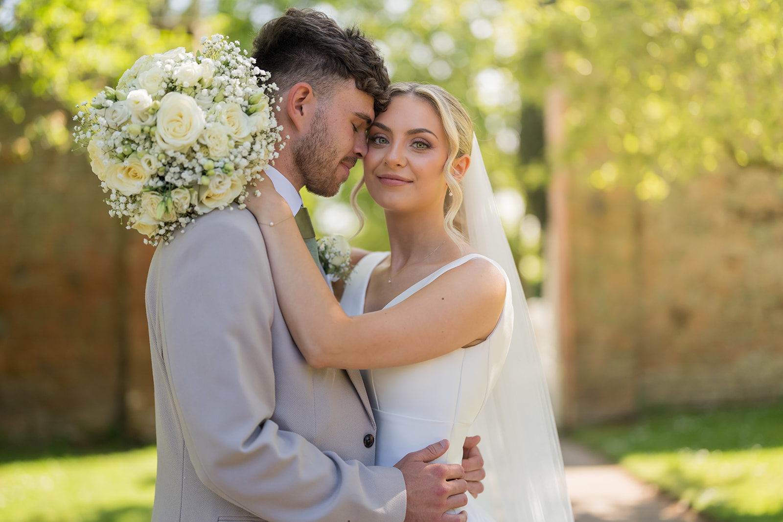 Bride and groom having outdoor portraits at Rylands Farmhouse wedding venue in Cheshire