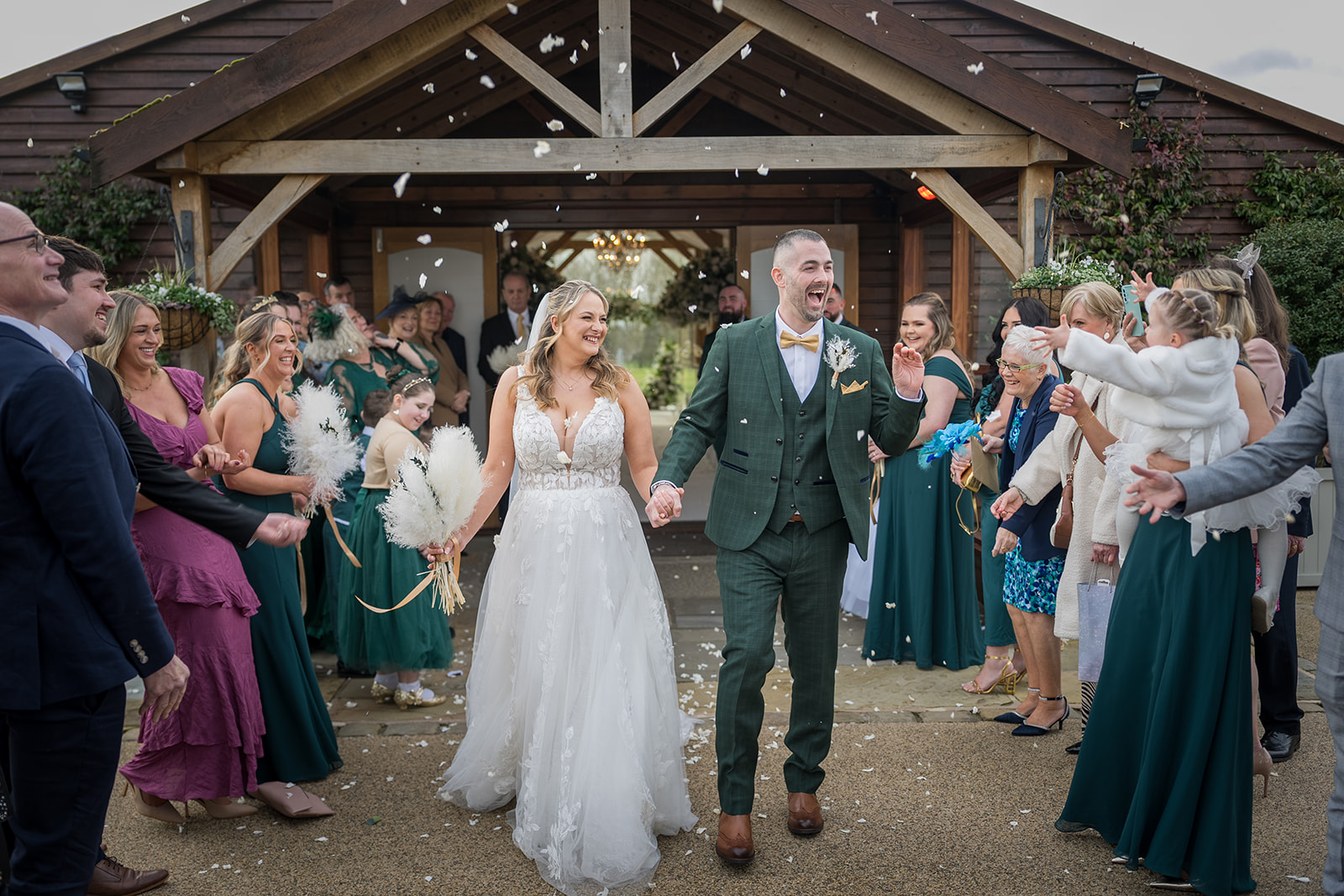 Bride and groom walking through confetti at Merrydale Manor 